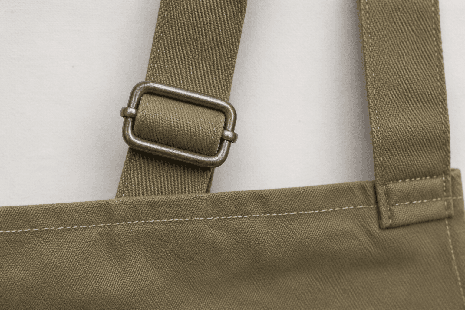Close-up of an adjustable slider buckle on an apron neck strap