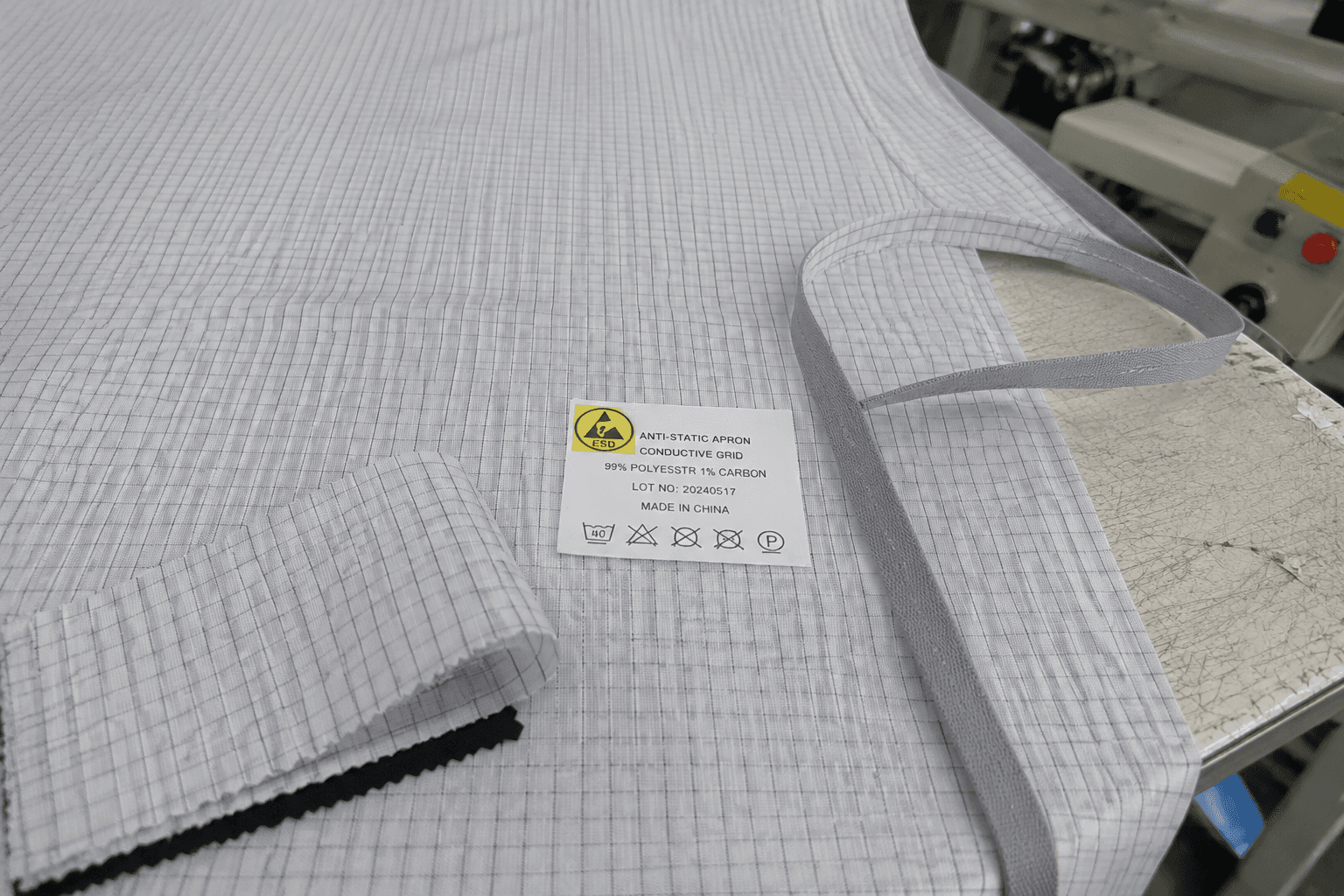 gray anti-static apron fabric with conductive grid lines and ESD label on a workbench