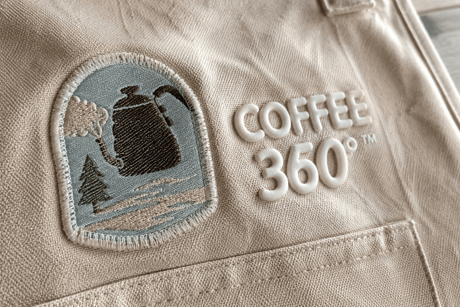 A raised appliqué patch and puff-printed logo on canvas apron fabric