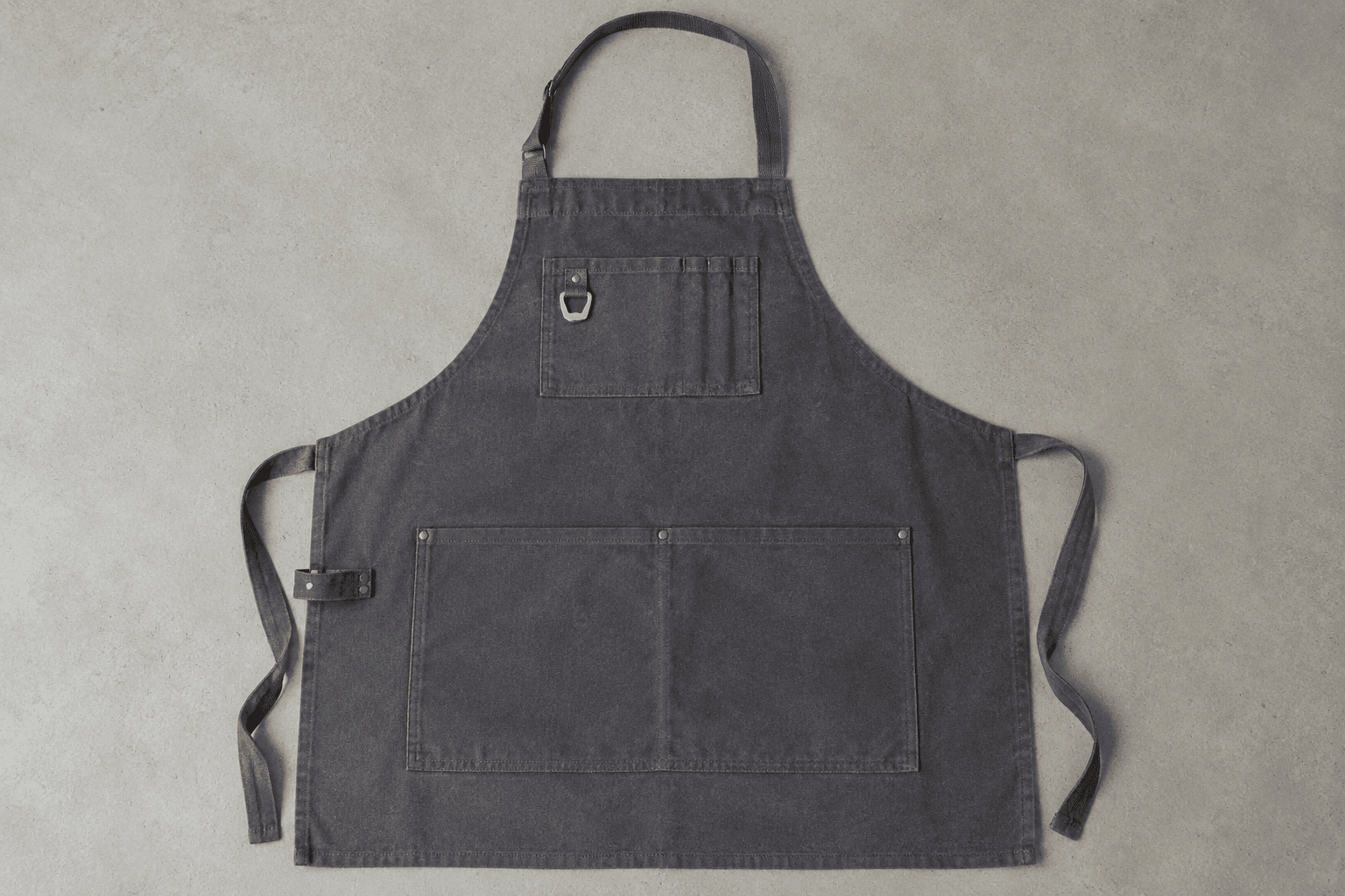 An apron front with a towel loop, riveted bottle opener and pen slots