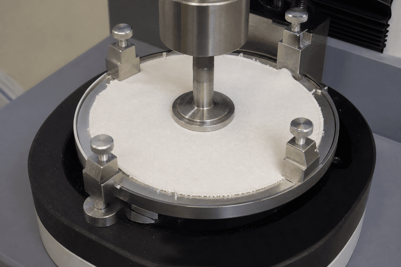 An apron fabric sample on an abrasion testing machine