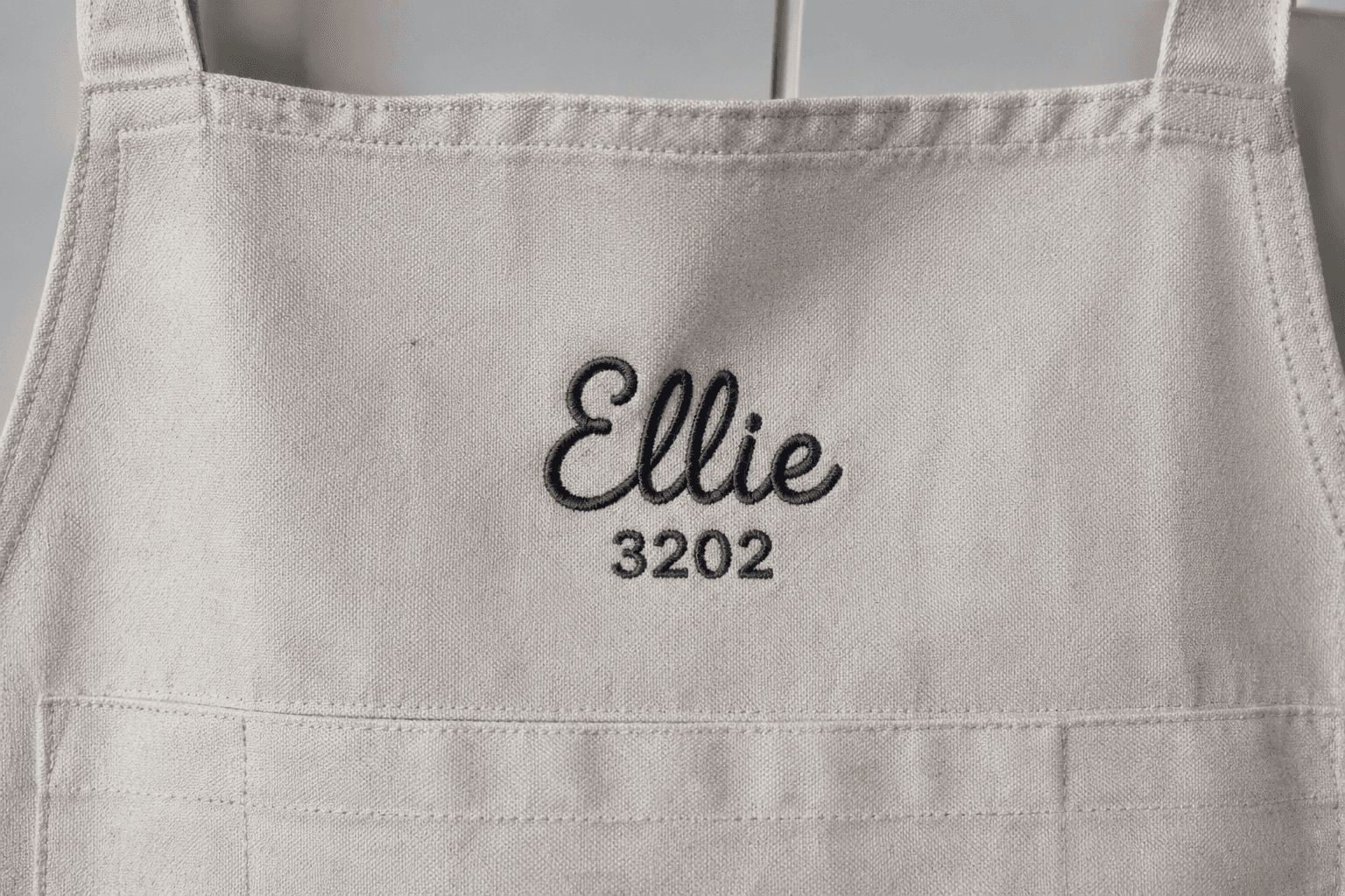 An apron hem embroidered with a name and a station number