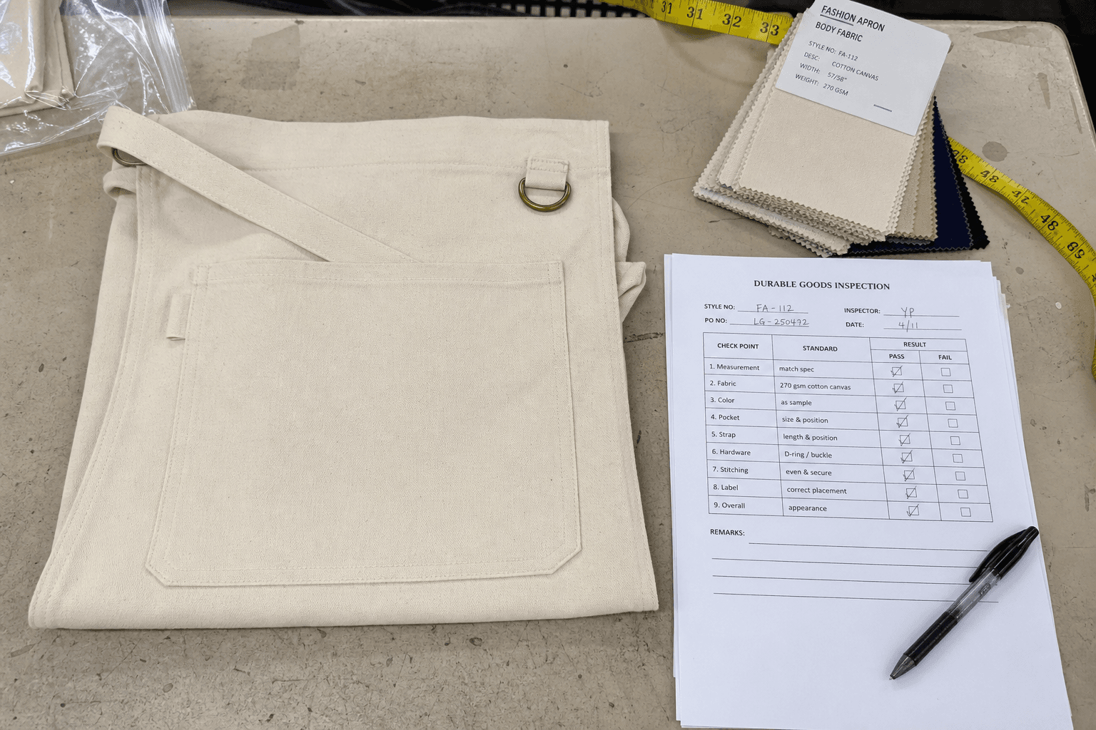 A quality-control table with a folded apron, swatches and an inspection checklist