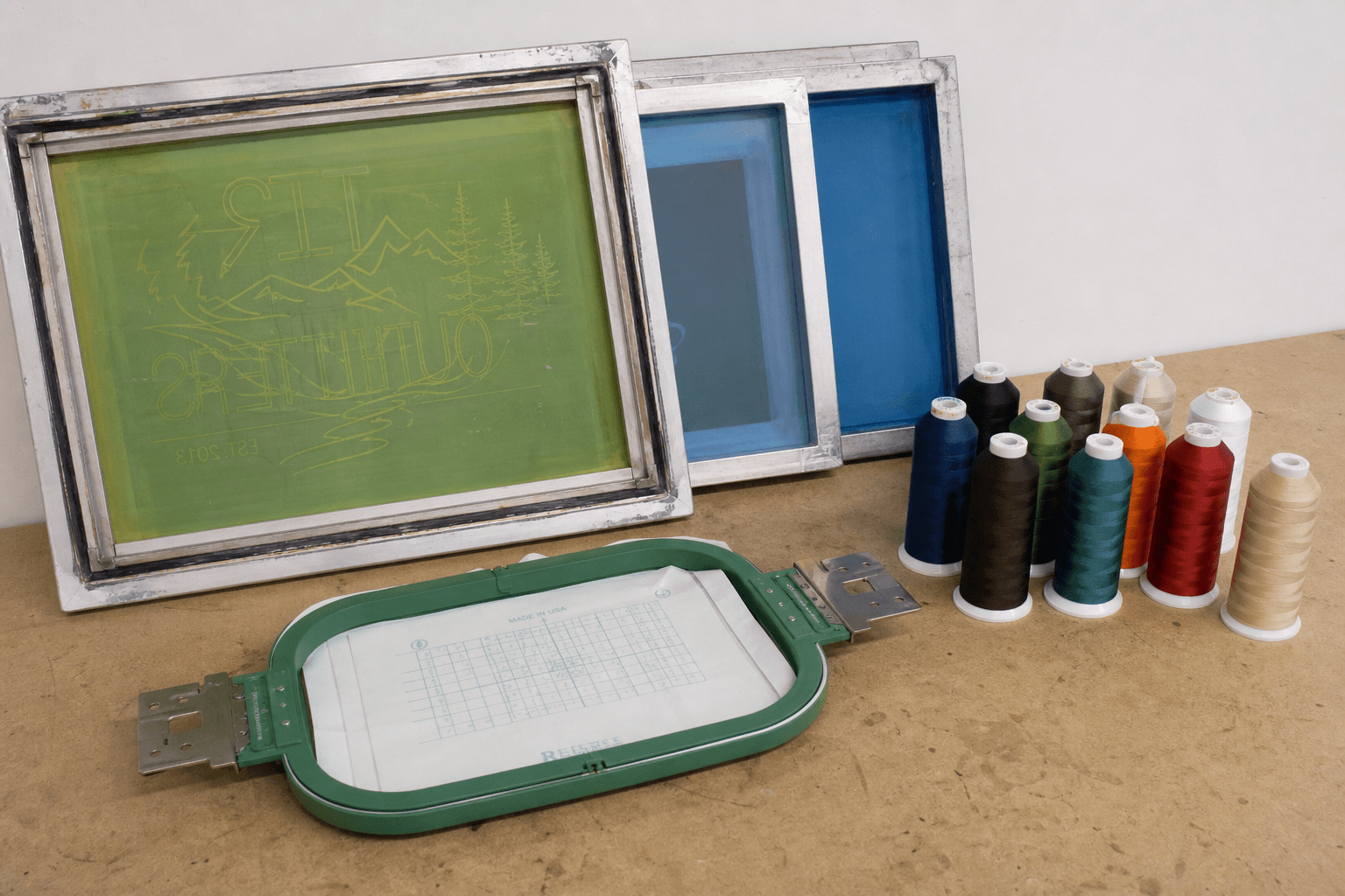 Screen-print frames and embroidery hoops on a workshop bench