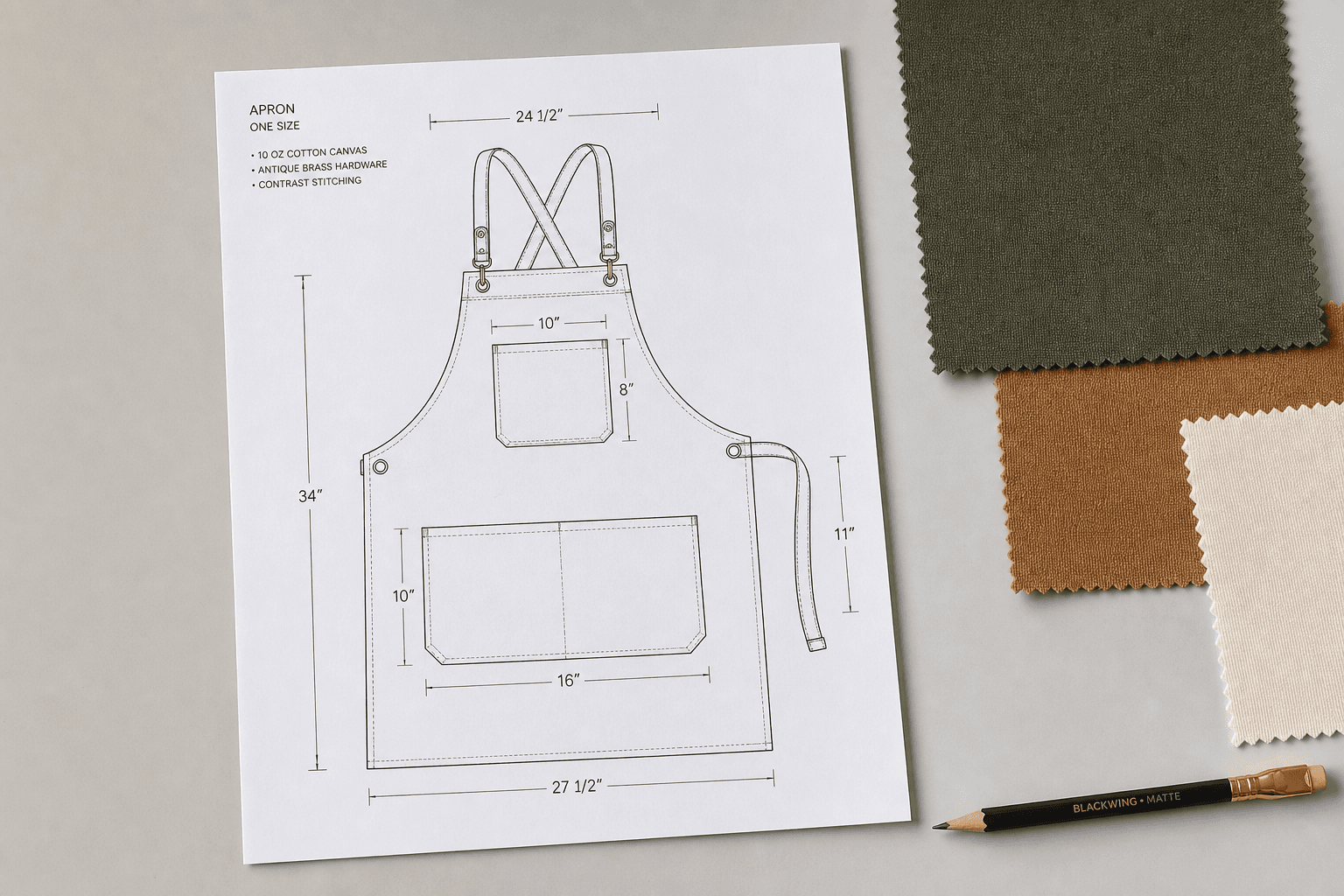 An apron technical drawing with measurements and fabric swatches on a desk