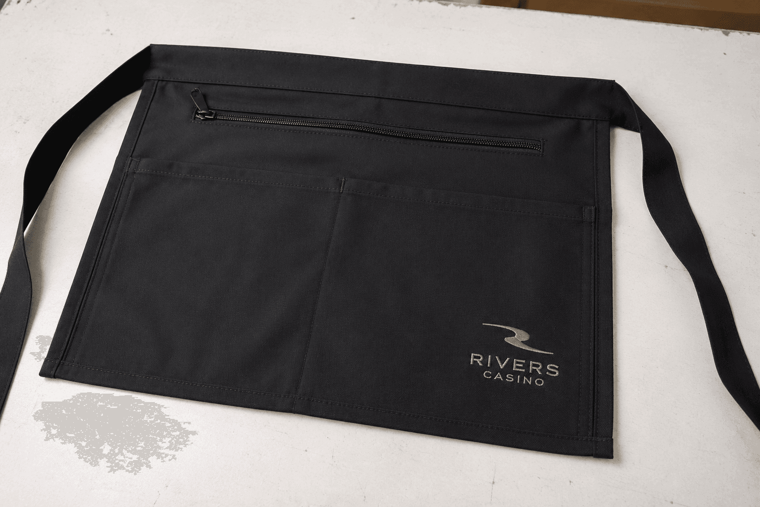 black casino service apron sample with secure zipper pocket and subtle logo embroidery
