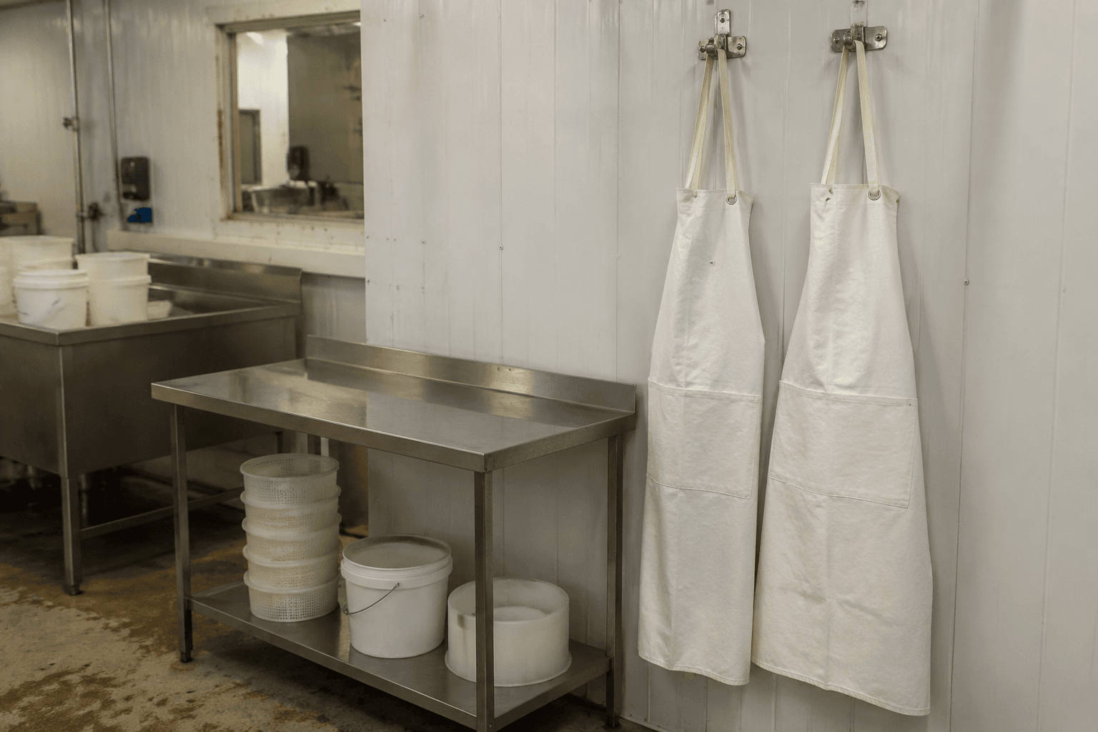 White hygienic creamery aprons hanging in a clean dairy workroom
