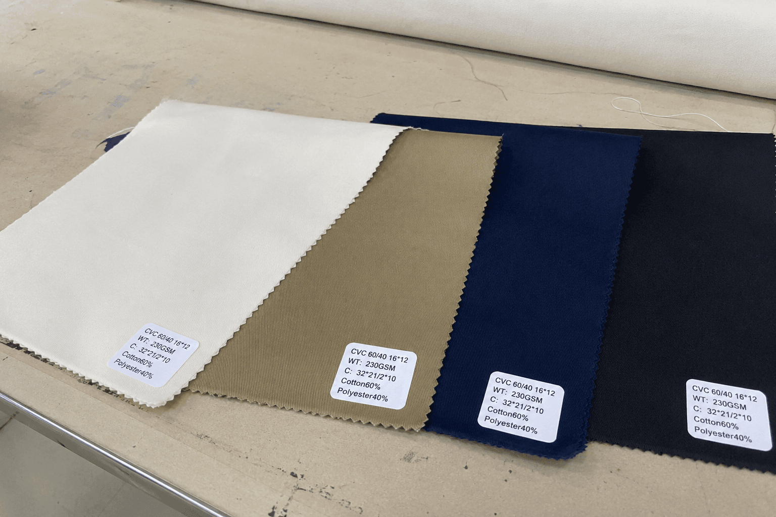 cotton-rich blended apron fabric swatches with fiber content tags on a cutting table
