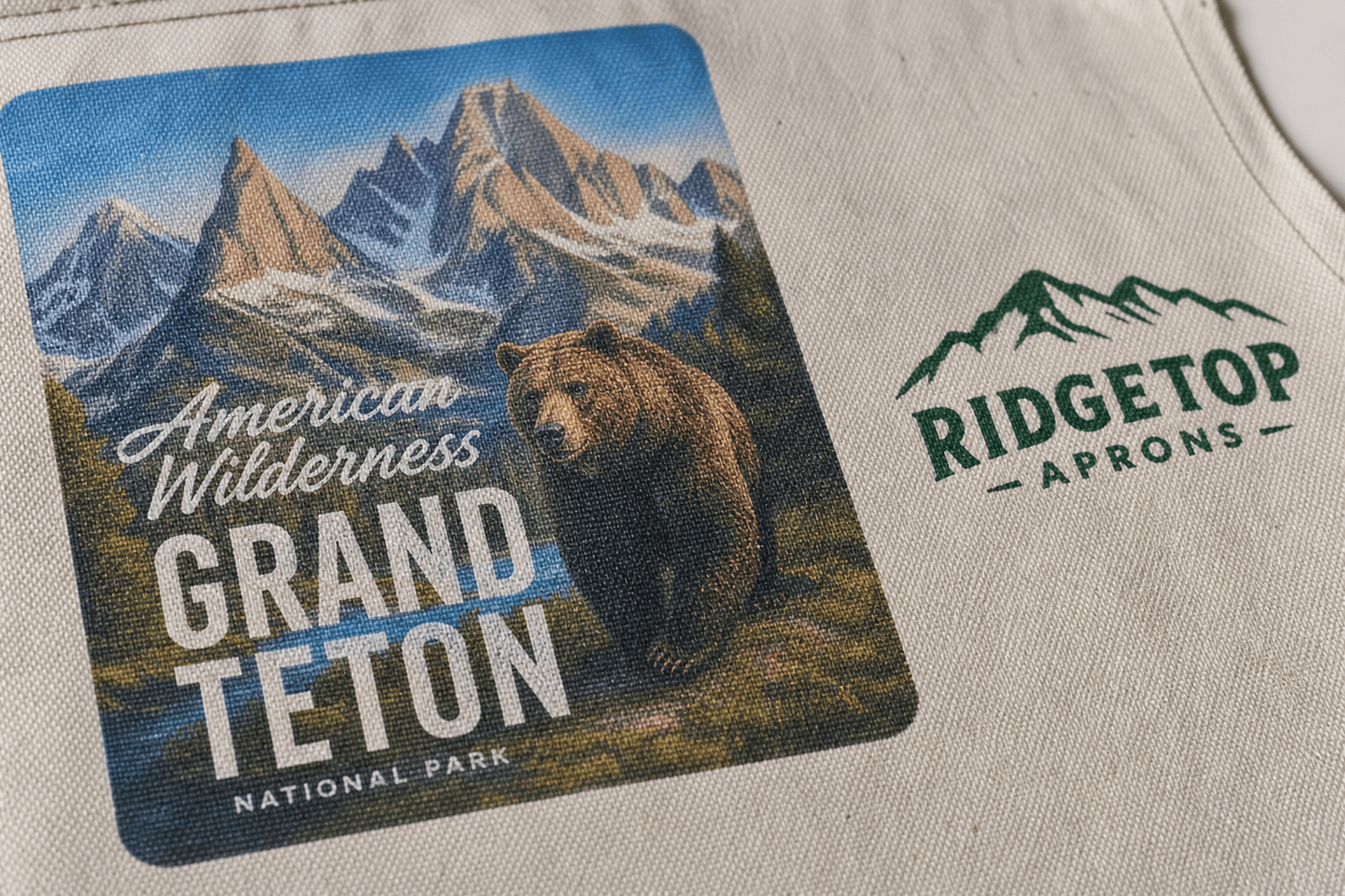 A full-color DTF-printed graphic beside a screen-printed logo on canvas apron fabric