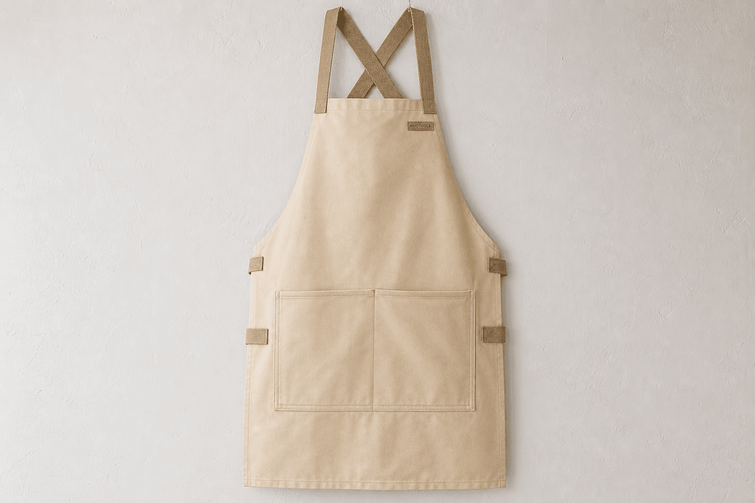A heavy splash-resistant pottery apron on a ceramics studio wall