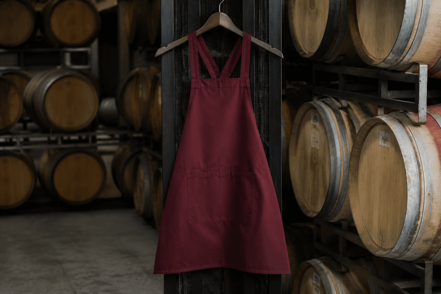 A dark crossback winery apron hanging in a barrel cellar